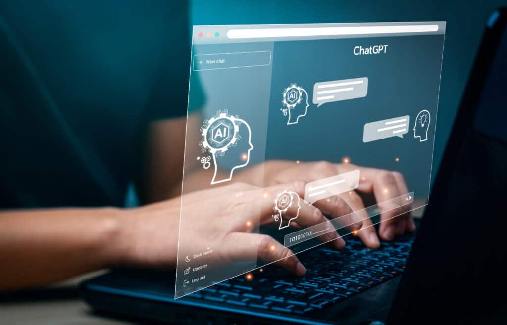 Die Hände einer Person liegen auf der Tastatur eines Laptops. Darüber ist grafisch eine Website gelegt. Innerhalb der Website steht ChatGPT sowie Ai. Außerdem sind darin Sprechblasen
